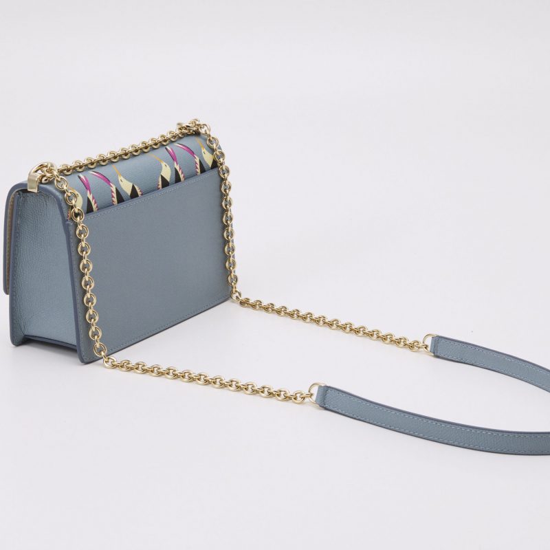 Produktfoto einer blauen Furla Designerhandtasche mit goldenem Henkel