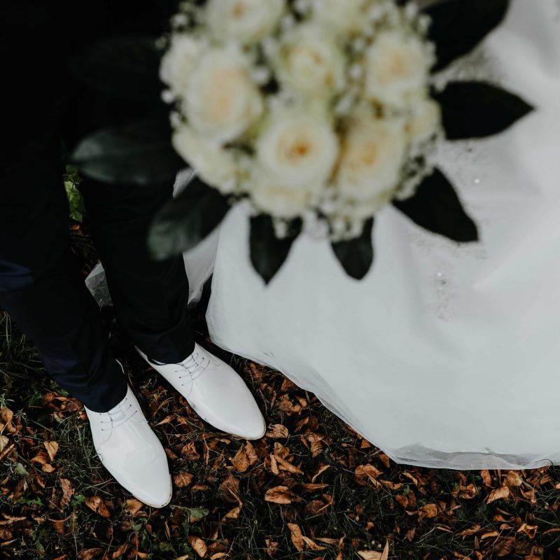 Detailaufnahme des Brautpaares mit schicken weißen Lackschuhen