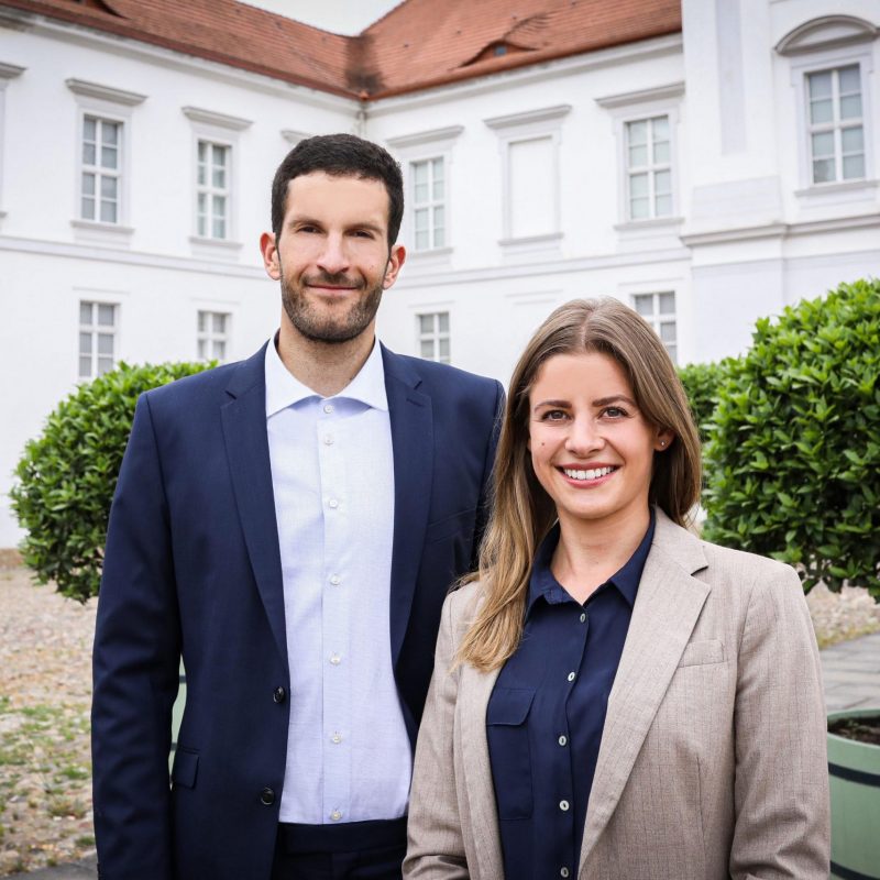 sympathische Geschäftsleute aus der Immobilienbranche vor dem Schloss Oranienburg